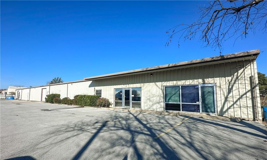 This flexible warehouse and showroom/office space offers prime visibility just off SE J Street, a high-traffic corridor with over 18,000 vehicles per day in the heart of Bentonville’s rapidly growing commercial district. Ideally positioned only 0.6 miles from the new Walmart Global Campus, 1.5 miles to I-49, and 2.3 miles to the Bentonville Square, the property provides exceptional accessibility for employees, customers, and logistics. The well-equipped warehouse features two 10’ x 10’ roll-up drive-in doors, 11’ clear height, and heated space suitable for a variety of operational needs. A comfortable, client-ready showroom and office area with full HVAC supports sales, administrative work, and customer interaction, while 18 dedicated on-site parking spaces offer convenient access in a dense office corridor near major Northwest Arkansas employers.