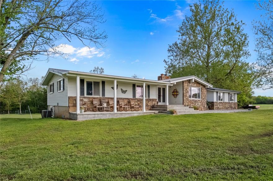 Come home to it all; 10.2 acres anything you can dream is here. 4000+ SF home w/ FULL basement! Metal roof/steel siding/rock, 4 yr old windows/doors, updated heat pump/AC, OZARK GO Fiber, 2 car gar., 2 covered porches, 2 chimneys, French drain, whole house filtration system. Upstairs: 2200+ SF, 4 BR/2.5 BA, office, stone fireplace, 2 w/d hookups, granite counters w/double oven, pantry/closet, reclaimed wood floors in living room, tile/new wood laminate/carpet, stained glass fixtures, vaulted ceiling. Full basement: 1900 SF hvac, wood stove, storage, utility sink, floor drain, walk-out doors. SHOP: 20x30ft, 110/240 power, restroom, wood stove hook-up.Gated w/mature trees, well and rural tap pd/avail. Conduit for landscape lighting/elect. entrance gates! 5 fruit trees/est. vineyard. 2 barns w/ loafing shed; 3 paddocks/fields fenced, water & elect. outlets for each; chicken house, raised & insulated, auto door, electricity/water spigots. 41x21 swimming pool w/commercial DE Filtration & pump. NO comm. poultry farms!