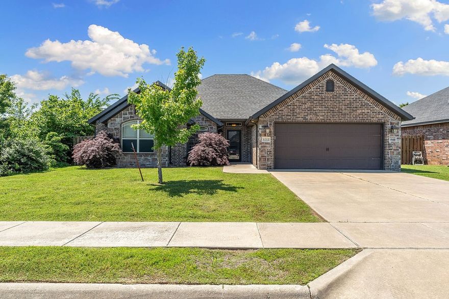 In the heart of NWA, this all-brick, split floor plan beauty blends convenience, charm, and privacy. Walk to elementary school, easy access to shopping, restaurants, parks, & entertainment. You’ll love being in the middle of it all—while still enjoying peaceful seclusion in your fenced backyard, surrounded by trees. Spacious, layout features vaulted ceilings, smart-wired tech hub, & notable touches like a cozy fireplace and kitchen desk. Eat-in kitchen is made for gathering, with an island, pantry, corner sink with backyard views, & sliding doors leading to the extended porch with hot tub hookup -- perfect for entertaining or watching kids play on the swing set. Kitchen fridge conveys. Retreat to a large primary suite with tray ceiling, double closets, double vanities, whirlpool tub, and separate shower. Two additional bedrooms each offer something special—one with tray ceilings, the other with vaulted ceilings, both feature spacious walk-in closets. The second full bath includes a tub and single sink.