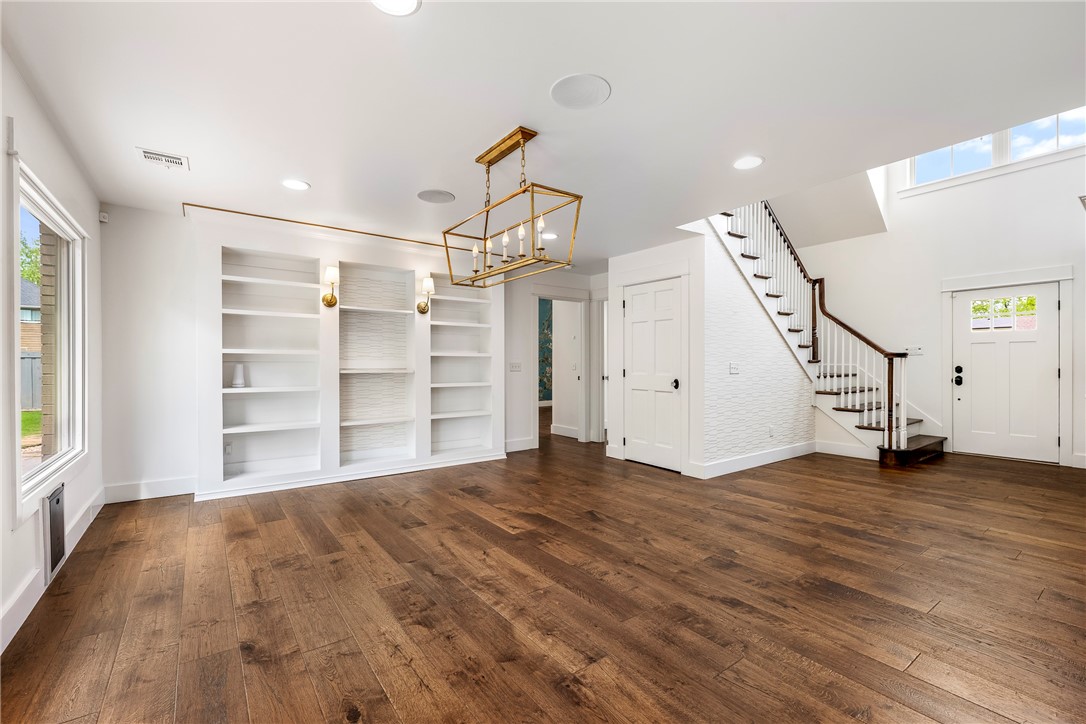 Located just a short stroll from the lively Bentonville Square, this exceptional home on an expansive corner lot is a showcase of style, sophistication, and thoughtful design. Bathed in natural light, the open-concept living area features rich wood flooring, custom built-ins, and a vaulted ceiling that soars above the chef’s kitchen, complete with upgraded appliances and ample workspace. The main-level primary suite offers a serene retreat, while upstairs, you’ll find two generously sized bedrooms with a shared bath, a third bedroom with an ensuite bath, and a versatile second living area that can serve as an office, playroom, or fitness space. Fresh paint, central vacuum, and a new custom carport designed to accommodate an RV or large vehicle elevate the home’s functionality. With its elegant finishes, spacious layout, and enviable proximity to Bentonville’s best dining, shopping, and cultural attractions, this home offers luxury living at its finest.