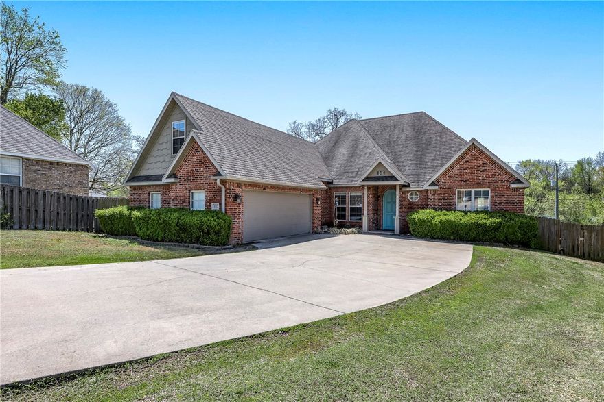 This stunning home offers an unbeatable location and a spacious layout perfect for comfortable living and entertaining. 1 mile to I-49, 1.8 miles to Arkansas Children's Northwest Hospital and close to schools. The expansive living room features polished concrete flooring, tall ceilings, elegant crown molding, and a cozy gas fireplace. The kitchen boasts a large island, granite countertops, stainless steel appliances, and a charming eat-in area with views of the backyard. A formal dining room with vaulted ceilings, wood floors, a chandelier, and natural light adds to the home’s charm. The primary suite impresses with a tray ceiling, crown molding, abundant windows, and access to a bright sunroom. The ensuite includes double sinks, a jetted tub, a walk-in tile shower with dual shower heads, and two walk-in closets.With all bedrooms on the main level—plus a versatile fourth bedroom or bonus room upstairs—and outdoor spaces including a sunroom.With acceptable offer seller will provide $8,000 towards carpet and paint.