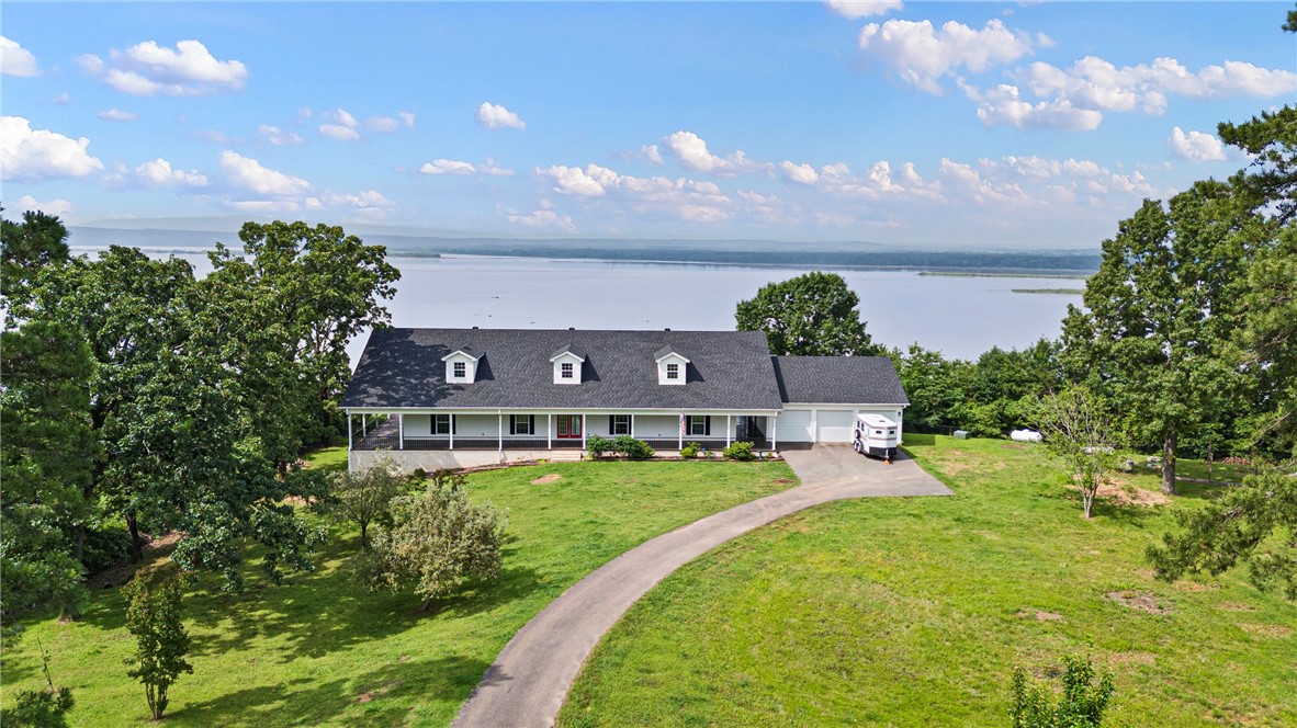 Miraculous, panoramic views and a grand home on the water! On the interior, you will find 3500 SF, open floorplan, 3 BRs, 2.5 baths, a large office/study with built-ins surrounding so it could be used as a library, laundry room and ample storage closets and storage rooms throughout the home. There is also an additional room off of the breezeway that is heated & cooled and could easily be turned into an additional bedroom by adding a closet space. On the exterior you will find a covered porch that wraps around the entire home and 3 car garage with a heated & cooled work room. The large storage space with overhead door access under the home has a cellar with electric. If finished this could add 1,000 SF. New HVAC (2). New roof. All top of the line appliances. Propane tank for new Viking gas range. New fencing surrounding property.
