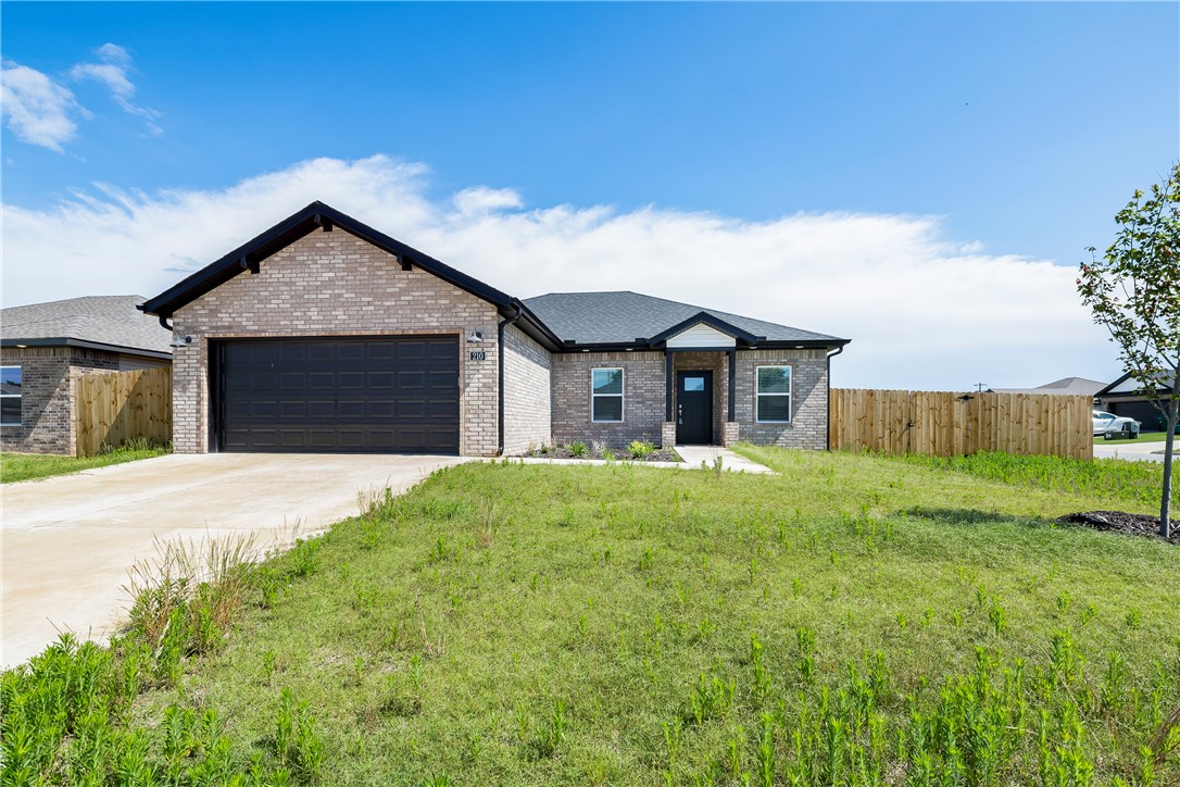 Single-story brick residence featuring a dark asph