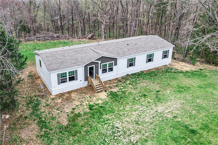 Welcome to 202 Silver Ridge Road — a brand new 2024 modular home tucked away on 5.36 private acres in the heart of the Ozarks, just minutes from charming Eureka Springs. This spacious 4-bedroom, 3-bath retreat offers 2,128 square feet of thoughtfully designed living space on a permanent block foundation. The open layout features wood laminate flooring, a cozy fireplace in the family room, an eat-in kitchen with pantry, and generous walk-in closets throughout. The primary suite is a true escape with a soaking tub and walk-in shower. A bonus room adds flexible space for work or play. Step outside to enjoy your deck, patio, and porch surrounded by the beauty and quiet of 5 wooded acres. With public water, no flood zone, and no covenants — this is the peaceful Ozark lifestyle you've been looking for.
