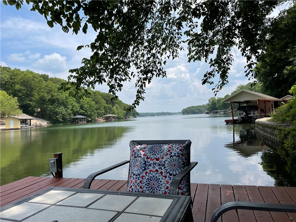 This immaculate and spacious Lake Loch Lomond home welcomes you to the wonders of lake living. Enjoy your peaceful shaded paved trail to the lake and your 48' x 19' dock with a 22'x11' boat slip complete with your pontoon boat that is included with the home. The perfect setup to enjoy lake living with family and friends. When not on the lake you will enjoy your multiple areas to relax with a large welcoming living room that leads to your beautiful sunroom. The spacious primary suite on the main level includes a fireplace and large bath with an oversized walk in shower. The main level features another bedroom, office, kitchen and dining. Downstairs enjoy a large family room with wet bar, bedroom, two huge storage rooms plus a big 23x19 workshop that has ac/heat. The lower level outside has a large covered patio to enjoy the view to the dock and lake. Video tour at https://vimeo.com/832390074 and matterport tour at https://my.matterport.com/show/?m=9hjYaE72goS&mls=1