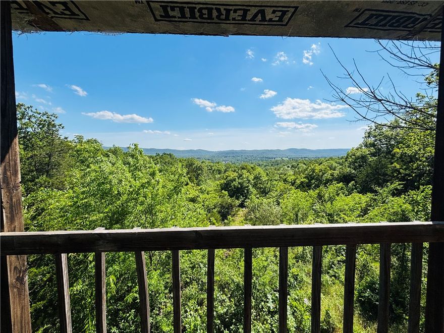 This one grabs you before you walk through the door—the moment you step onto the deck and the Rea Valley opens up in front of you. Eight-plus acres of Marion County ridgeline, forested and private, on a paved county road. White River and Cotter Bridge are a mile out. Flippin threemiles. Bull Shoals fifteen. Deep in the woods and still close to everything that matters out here. Electric is in. Decks on both floors, wrap-aroundon the main level. Inside: laminate floors, hickory cabinets, sliding barn door, Pella windows that frame those ridge views like they were meantto. A private staircase leads to the upper bedroom and reading nook. Septic and well needed, which means the right buyer finishes it exactly theway they want. No restrictions. Abundant wildlife. Serious potential.
