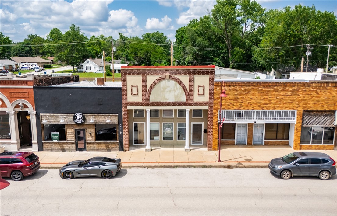 Prime Main Street visibility with the flexibility to live, work, or lease—this mixed-use space does it all. A welcoming front lobby leads to private offices, a half bath, and storage, making it a solid fit for a small business setup. The attached warehouse includes a full bath, washer/dryer combo, and both overhead and walk-through access from the back. Upstairs, the living space offers a separate kitchen, living/dining combo, bedroom, and its own entrance—ideal as a rental or residence. Two rear parking spots plus street and city lot options keep access easy for clients and tenants.