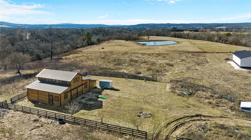 Perfect property to build your custom home & mini-farm! Level to gently rolling pasture with an awesome distant view over the stocked pond. The property is 0.3 miles from Blue Springs Rd, 2 miles from Goshen stores/restaurant, & a short distance to Fayetteville. Fayetteville schools - Vandergrift Elementary school.  2 barns: newer 36x52 barn with hay loft & plenty of room for 6 horse stalls & older 40 x 40 barn. Both barns have electricity & water running to them. The land is mostly pasture that is fenced & cross-fenced with a combination of wood rail & wire fencing. The land is tucked away between a wooded ravine to the north that separates the property from a subdivision of nice homes on small acreages & a nice home on 23 acres giving the property plenty of privacy & semi-seclusion. City water & electricity is on-site & ready to go! Ozark Go high-speed internet. The pond is stocked w/bass & crappie. Garden area with hydrant for irrigation. It is truly a picturesque setting just waiting for someone's dream home!