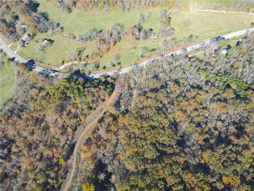 Set in the heart of the Ozarks, this 195-acre property offers a rare combination of accessibility, wildlife, and natural beauty. With direct frontage on U.S. Highway 412 and multiple gated access points, this land is as convenient as it is secluded.  A well-established internal road serves as the main artery through the property, providing easy access to numerous hunting stand locations and scenic vantage points. Two ponds add to the habitat mix and attract a variety of game.  Deer, turkey, and even black bear roam these woods, and it offers a truly fresh canvas for new management and infrastructure. With electricity already reaching the center of the tract, it’s suitable for a hunting camp, cabin site, or future home base.  The eastern portion carries an amazing mix of a large, relatively flat plateau paired with a beautifully rugged bluff.  The bluff can be easily descended in multiple places, depositing you onto yet another shelf, allowing for gorgeous hikes or hunting among house-size boulders and crevasses.