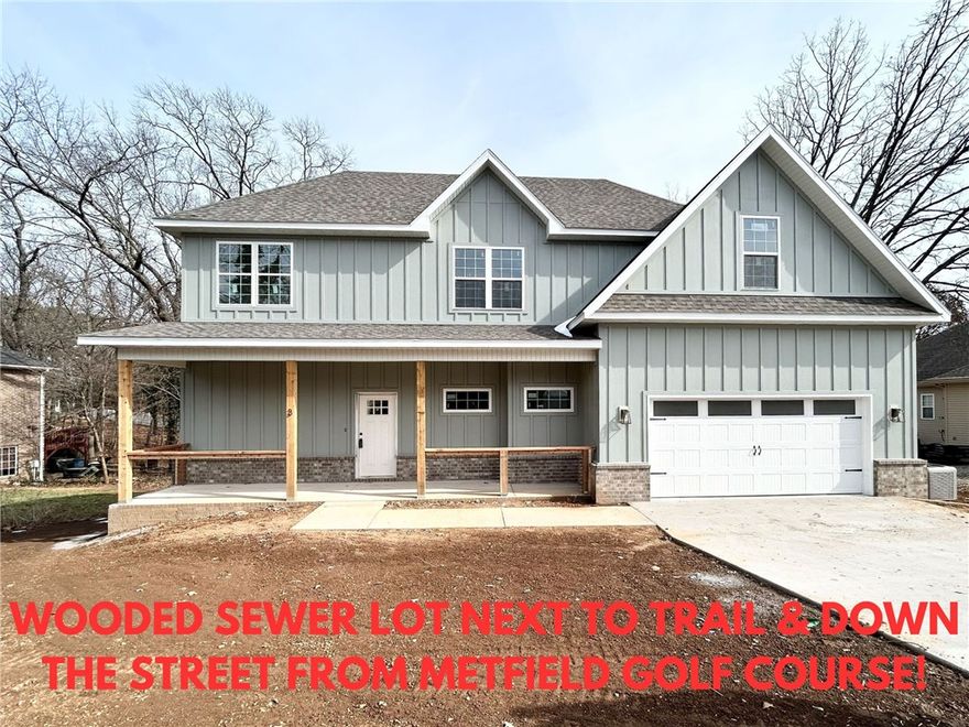 New construction on a very nice street with a bonus room. Wooded sewer lot with FLAT backyard next to a Trail Crossing and down the street from Metfield Golf Course! Easy access to Bentonville! This stunning property offers the perfect blend of nature and nearby amenities. Step inside to discover wood floors, a beautiful fireplace, custom cabinets, and elegant 3 cm quartz countertops. The expansive kitchen and gas range is perfect for entertaining. This thoughtfully designed home features 3 spacious bedrooms plus a versatile bonus room. The primary bedroom is conveniently located on the main level. There is also room for a shop. Bentonville schools. As an added bonus, this home includes $3,500 in buyer's closing costs when using the builder’s preferred lender!