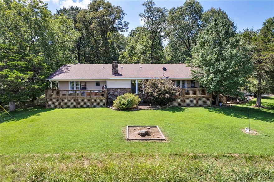 Nestled in a private, picturesque setting just 1 mile from the lake, this 3-bedroom, 2-bath home offers a tranquil retreat for nature lovers. Surrounded by mature trees and a mix of wooded and pastureland, it sits on a scenic hill with peaceful valley views, two serene creeks, and a beautiful winter view of Beaver Lake. Inside, you’ll find wood floors in the master and family rooms, a large den, and a striking floor-to-ceiling natural rock fireplace with gas logs (convertible to wood-burning). The home features a Bosch dishwasher, pantry, and generous kitchen island for both cooking and gathering. Equipped with an alarm system and accessed via a legal easement off JD Stahl Rd, this home is both secure and secluded. Enjoy the outdoors with two spacious decks—one featuring an oversized Hot Springs hot tub. The property also includes a versatile pole barn, shed, a 45-foot gravel RV parking area and two-car carport, offering plenty of storage and workspace. Peaceful, well-kept home surrounded by nature and privacy.