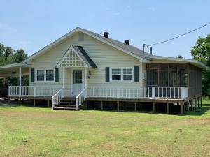 Peaceful and Serence. Perfect little cottage surrounded by trees. Custom one owner home. Large living and kitchen combined. Two bedrooms with Jack and Jill bath. Enjoy the evenings on large screened porch. Nice storage building adjacent to carport. New flooring throughout.