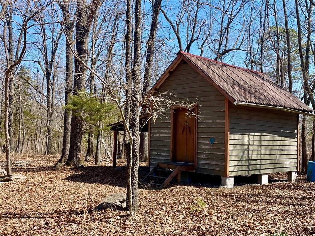 Discover your slice of paradise with 16+ unrestricted acres on a secluded ridgetop in the quiet Hogscald Hollow area of Beaver Lake near Eureka Springs. Rustic 12 x 16 sleeping cabin with an attached pole shed for additional covered storage. Numerous building sites with views to the east or west and with southern exposures. Deer, bear, turkey and other small wildlife and a variety of birds. Electric company easement on one end of the property provides easy access to electric. Well and septic needed. Small pond filled by rain water. Private road dead ends on the property and is maintained by the property owner. Only 1.25 miles to Beaver Lake public access and 10 miles to downtown Eureka Springs.
.