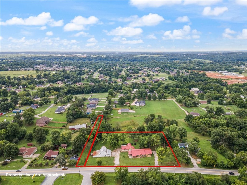 Cave Springs is growing rapidly and now is the time to capitalize on the opportunity! This charming property holds endless possibilities for homeowners, investors and entrepreneurs alike. It includes 300' of highway frontage, 1.84 acres and multiple access points. The home has a rustic flair with a master suite addition (2010), new metal roof (2012), kitchen remodel (2018), new A/C unit (2023), new LVP flooring (2025) and updated guest bath (2025). Outside you'll find a huge barn with 5 separate bays, detached 2-car garage with separate workshop w/ rollup door, 2 separate carports AND a storage shed. For that buyer that needs 'room to work' this place has it all! With XNA airport just to the west, I-49 minutes away to the east, and the potential to rezone to Commercial....this location has so much to offer!