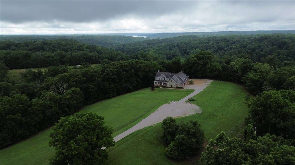 Welcome to 11010 Meadow Lark Rd in Rogers, Arkansas. First time ever on the market, this custom-built dream home is nestled at the end of a quiet cul-de-sac on 2.53 acres, backing up to mature trees for a peaceful, wooded backdrop. Ideally located just 10 minutes from downtown Rogers and less than 20 minutes from the new Walmart Home Office, this property offers both convenience and privacy.
With three spacious levels and a total of 5,130 heated square feet, there’s plenty of room to spread out while still enjoying a warm and inviting atmosphere. Thoughtfully designed with quality craftsmanship throughout, the home features a safe room, a partial backup generator, and energy-efficient solar panels that keep utility bills remarkably low. Perfectly suited for everyday living and entertaining, this one-of-a-kind retreat offers timeless finishes, modern comforts, and a tranquil setting you’ll fall in love with the moment you step inside. Don’t miss your chance to own this sanctuary in the heart of Northwest Arkansas.