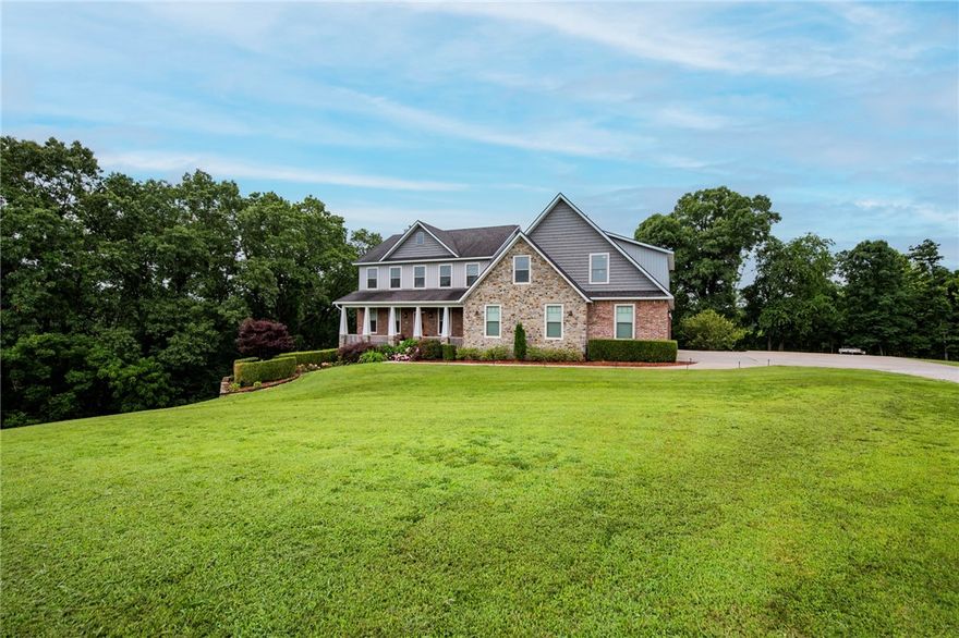 Welcome to 11010 Meadow Lark Rd in Rogers, Arkansas. First time ever on the market, this custom-built dream home is nestled at the end of a quiet cul-de-sac on 2.53 acres, backing up to mature trees for a peaceful, wooded backdrop. Ideally located just 10 minutes from downtown Rogers and less than 20 minutes from the new Walmart Home Office, this property offers both convenience and privacy.
With three spacious levels and a total of 5,130 heated square feet, there’s plenty of room to spread out while still enjoying a warm and inviting atmosphere. Thoughtfully designed with quality craftsmanship throughout, the home features a safe room, a partial backup generator, and energy-efficient solar panels that keep utility bills remarkably low. Perfectly suited for everyday living and entertaining, this one-of-a-kind retreat offers timeless finishes, modern comforts, and a tranquil setting you’ll fall in love with the moment you step inside. Don’t miss your chance to own this sanctuary in the heart of Northwest Arkansas.