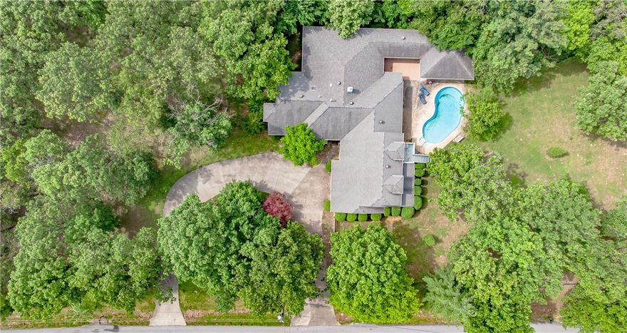 Discover your private retreat just under a mile from Coler Mountain Bike Preserve. Nestled on 2.21 wooded acres in the highly coveted Oak Hills community, this beautiful home and setting offers a serene escape with room to live, work, and entertain. Step outside to enjoy the expansive covered composite deck, in-ground pool, and screened-in hot tub—ideal for year-round gatherings. Inside, large windows fill the home with natural light and frame peaceful views of the surrounding trees. The executive office includes custom built-ins and overlooks the natural landscape, while the spacious walk-out basement offers flexible space for a home gym or recreation area. Multiple guest suites with private exterior entrances provide versatile hosting options, and a detached workshop with RV parking provides even more convenience. Come experience the potential this Oak Hills retreat has to offer!Back on the market at no fault of Seller or Home!