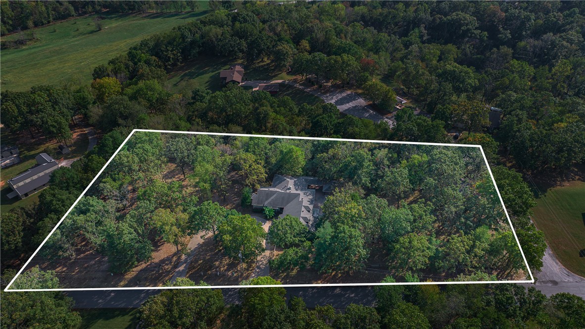 Discover your private retreat just under a mile from Coler Mountain Bike Preserve. Nestled on 2.21 wooded acres in the highly coveted Oak Hills community, this beautiful home and setting offers a serene escape with room to live, work, and entertain. Step outside to enjoy the expansive covered composite deck, in-ground pool, and screened-in hot tubāideal for year-round gatherings. Inside, large windows fill the home with natural light and frame peaceful views of the surrounding trees. The executive office includes custom built-ins and overlooks the natural landscape, while the spacious walk-out basement offers flexible space for a home gym or recreation area. Multiple guest suites with private exterior entrances provide versatile hosting options, and a detached workshop with RV parking provides even more convenience. Come experience the potential this Oak Hills retreat has to offer!
