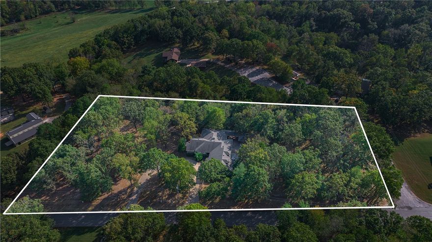 Discover your private retreat just under a mile from Coler Mountain Bike Preserve. Nestled on 2.21 wooded acres in the highly coveted Oak Hills community, this beautiful home and setting offers a serene escape with room to live, work, and entertain. Step outside to enjoy the expansive covered composite deck, in-ground pool, and screened-in hot tub—ideal for year-round gatherings. Inside, large windows fill the home with natural light and frame peaceful views of the surrounding trees. The executive office includes custom built-ins and overlooks the natural landscape, while the spacious walk-out basement offers flexible space for a home gym or recreation area. Multiple guest suites with private exterior entrances provide versatile hosting options, and a detached workshop with RV parking provides even more convenience. Come experience the potential this Oak Hills retreat has to offer!