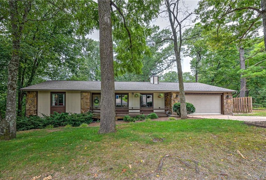 "Mid-Century vibe" home in the woods! Renovated kitchen and living areas. Move right in and enjoy the Tweety Bird mountain bike trail behind the home. (It is truly bikeable from your backyard) Newer LVP floors for easy care! There is an extra space in garage for workshop or finish out and add to your square footage. Affordable home with MCM Style!