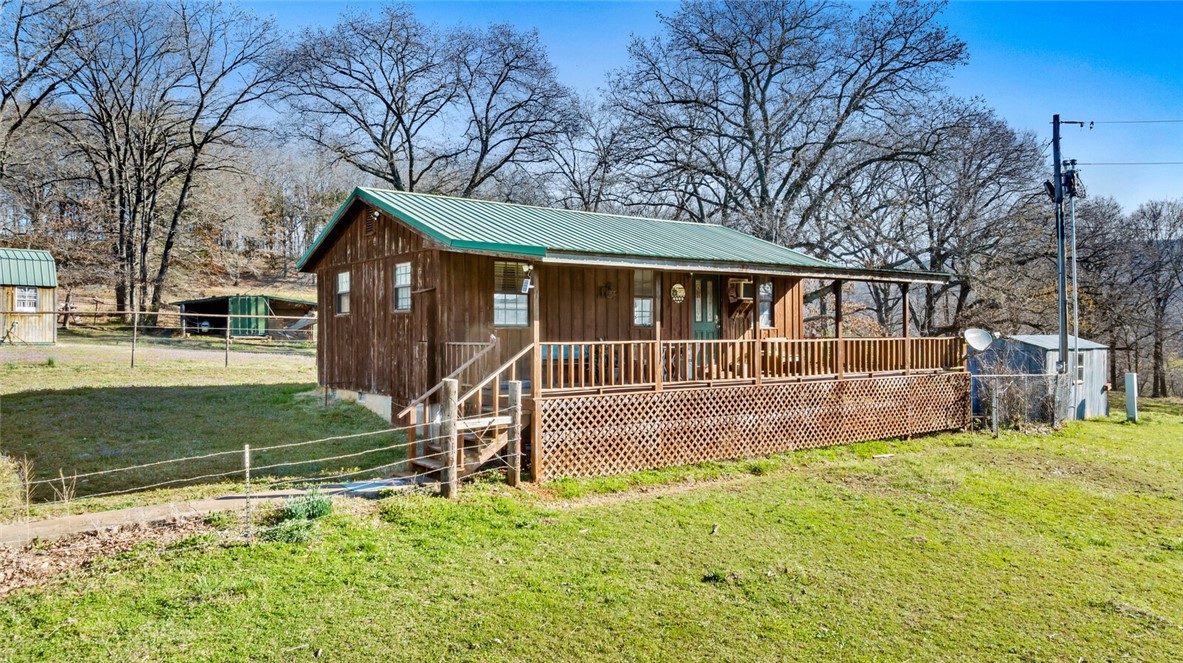 Ever dream of living in the country with views for miles? This is it! This 2 bedroom/1 bath 640 sq ft home sits on 24.79 acres. With mature trees, open pasture, an open barn for hay or horses, an insulated 30 x 40 metal shop - it has it all. Lots of opportunity to make this yours. The metal storage container behind the house does not convey. There are dogs on the property, but they should be contained.
Location is just 7 miles to Devil's Den State Park, 9 miles to Lincoln, and 10 miles to Prairie Grove.
Water is provided by Washington Water.