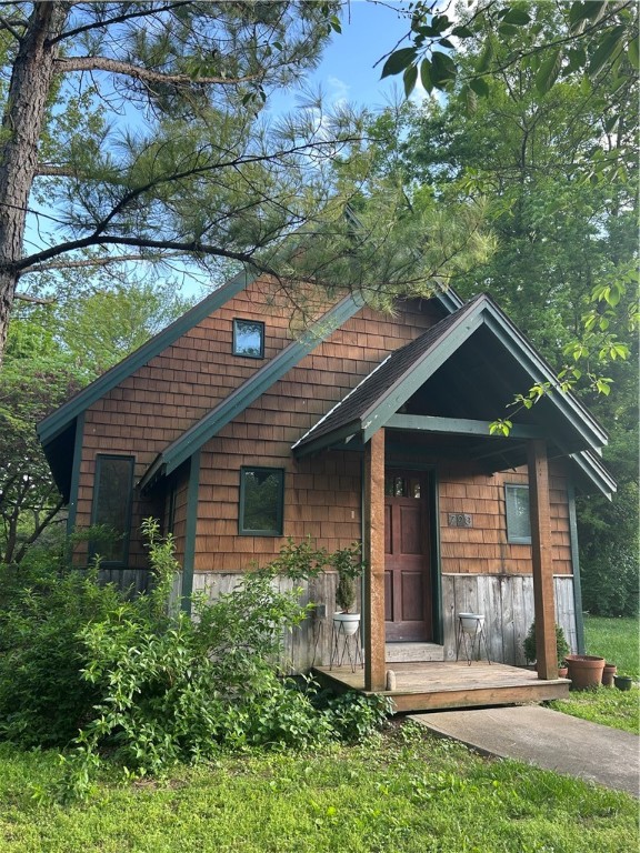This cottage-style home by renowned architect Ross Chapin using his Three Gable Home plan is a blend of Craftsman detail and cozy elegance. This two-bedroom, one-and-a-half-bath design showcases Chapin’s signature style. The exterior features a steep-pitched roof with three distinct front-facing gables, wide overhangs, and exposed rafter tails. Cedar wood siding and covered front porch invite you in with warmth and character. Inside, the floor plan maximizes comfort and functionality. The open-concept living, dining, and kitchen area is anchored by rich wood trim, built-in cabinetry, and large windows that bathe the space in light. Vaulted ceilings and clever storage make the home feel larger than its square footage. The primary bathroom is designed with Craftsman detailing while the half-bath adds convenience. The home highlights a spacious patio and large fenced backyard extending the living area. A new 14x20 shed can be used as a small shop or extra storage space.