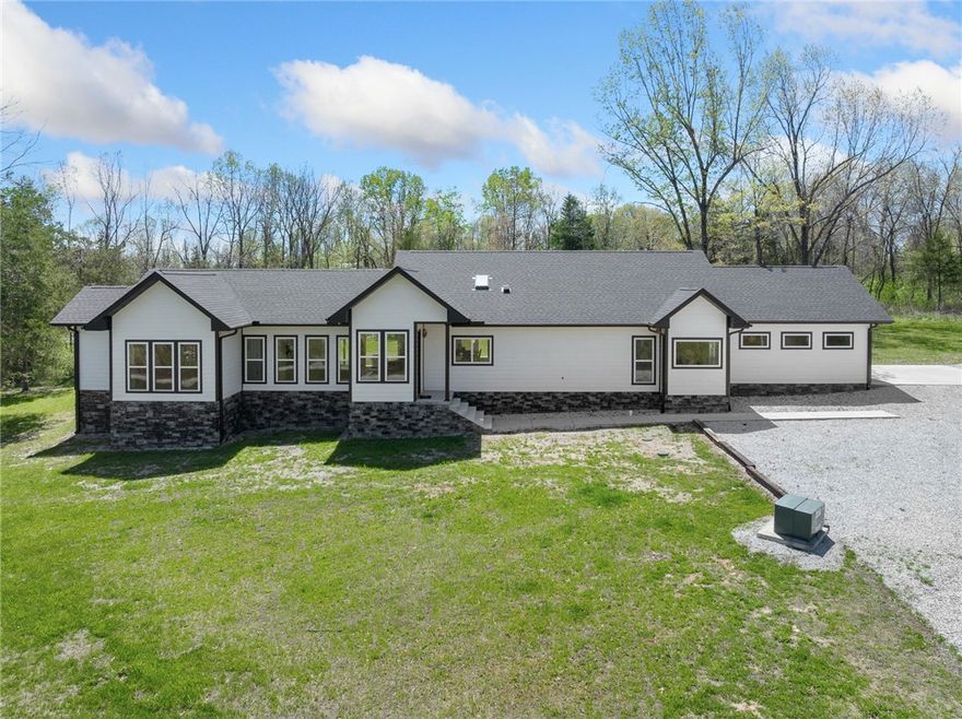 Welcome to modern country living where contemporary design meets self-sufficiency and peace of mind. Built in 2022 and now offered with 34 acres, this custom home sits on a quiet paved road just minutes from town. Designed with clean lines, energy efficiency, and natural light in mind, you’ll love the open layout, vaulted ceilings, and oversized windows that frame your wooded surroundings. The kitchen features quartz countertops, a large island, floating cabinetry, and a hidden pantry with a built-in tornado shelter for smart storage and safety. The home includes 3 bedrooms and 3 full baths, with a split layout offering two private suites ideal for guests or multigenerational living. Eco-conscious buyers will appreciate the green construction, high energy rating, whole-house generator, and pre-wiring for future solar panels. Efficient, minimalist, and thoughtfully designed, this home blends luxury with sustainability. Ideal as a private home, weekend retreat, or nightly rental investment.