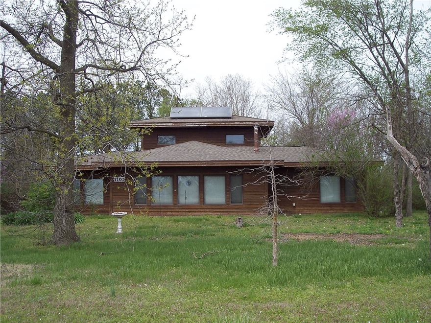 Attention Developers! A rare find! House & 8.6 acres (level) in town. Lots of potential! The house is a Stitt house. (Solar). It has 3 bedrooms & 3 baths, The value is in the land, however, the house is livable. Check it out! There are not many houses & level acreage in town for sale. Seller will not provide termite policy. Sold AS-IS.