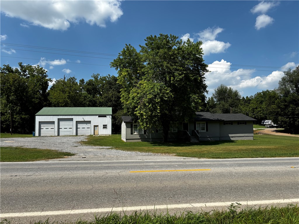 Major road frontage. High traffic count. This property sits about a mile from the XNA Airport entrance. The property sits on approximately 1.90 acres with a 3 bed (or office) one full bath house (1,612 sq ft +/-) and a three, overhead door shop (2,000 sq ft +/-). Previous tenants had a cabinet making business in the shop and used the house as an office. Would be great for a construction business, landscaping business or auto shop. Any commercial use will need to be verified with the City of Highfill.