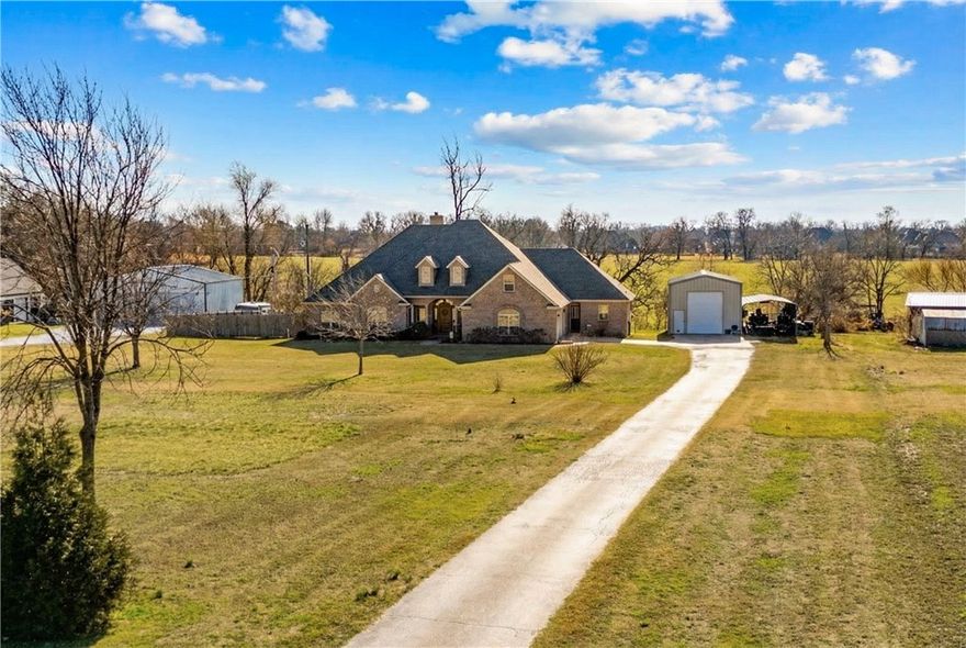 Set back from Elm Springs Road, a long paved drive creates a private sense of arrival to this primarily single-level home with only a bonus room upstairs. Brand new carpet and interior paint throughout. New AC unit. Office has both exterior entrance and interior access—ideal for a home business. Bonus room is tucked away from the main living—great for play or media. Three of the 5 bedrooms have full bathrooms. Walk in attic storage with power and height for ease of manueverability.

Covered deck off dining and living area is ideal for bkyrd entertaining. Expansive 1000 sq ft powered shop, attached two car garage, covered carport, and backyard shed provide substantial storage and workspace. Wired for whole house generator and single switch holiday lighting. Pear, pecan, fig, mulberry and magnolia trees to enhance your garden.

Springdale Schools. Minutes to Hwy 49, Hwy 612, XNA, Downtown Bentonville, Elm Springs Super Walmart, & Shaw Park. No POA fees or Covenants. Exceptional space, access, and flexibility.