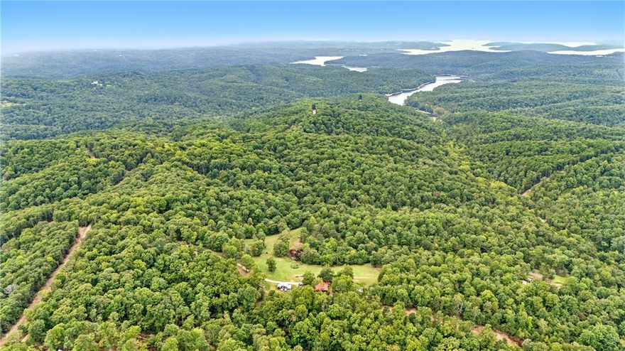 Wonderful opportunity to own a mobile home on 20 scenic acres near Beaver Lake and Hobbs State Park. Nestled near the end of a tranquil, long dirt road, this mobile home sits on 20 beautiful acres, offering unparalleled privacy and natural beauty. The value lies in the expansive 20 acres, surrounded by rolling hills, mature trees and abundant wildlife, perfect for outdoor enthusiasts, hobby farmers, or those seeking a serene escape. With no close neighbors and the peace of rural living, this property is located in Madison County, only 20 miles from Rogers and Eureka Springs.Multiple structures on site as well as electricity, septic tank, and county water.
The existing mobile home with a  60’ x 20’ addition requires significant repairs and is being sold as-is, offering a blank canvas for those with a vision to renovate or who would prefer to build a new custom home. Don’t miss your chance to invest in this stunning 20-acre parcel with endless potential.