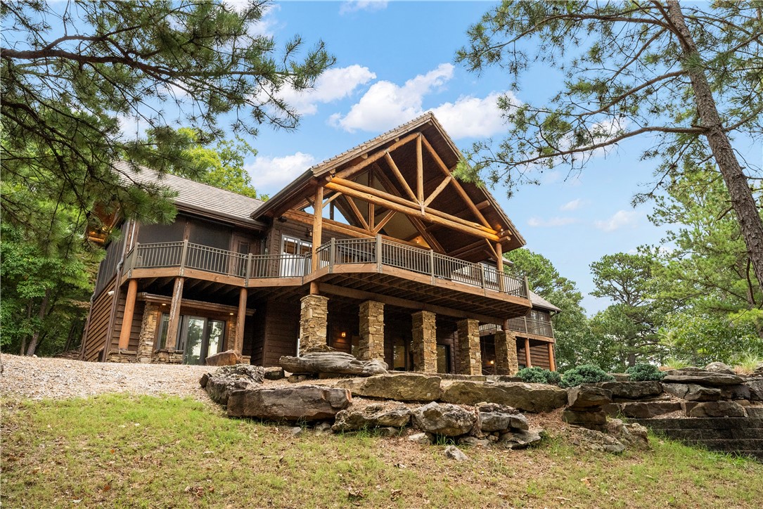 "The HIDEOUT" - This architecturally designed lake house is quality finished with attention to detail! Nestled right on Beaver Lake on its own private point, this beautiful craftsman-style home is covered with log accents, cedar and rock. On 3.85 acres, this home includes a 1,000 ft shoreline, a private 2 slip dock with a swim platform, and a property gate with external surveillance. Entire primary floor equipped with automatic electric awning/blinds. Special features in the home include Australian Cypress floors, solid alder doors, wood windows, granite, travertine, has a large exterior upper deck, patios outside each bedroom, and a lovely screened porch. You will not want to miss the 16x14 office with windows, vaulting, with a one of a kind lake view! 20 min to Rogers.