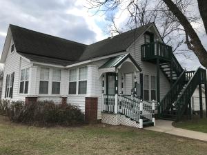 Charming historic home completely updated setting on half a Block. Enclosed pouch, new windows and siding, tall ceilings, large kitchen with new tiled countertop and tiled floor, added cabinets, new wood flooring, gas fireplace,new central H/AC, two bedrooms and bath upstairs, detached carport and storage with large yard.