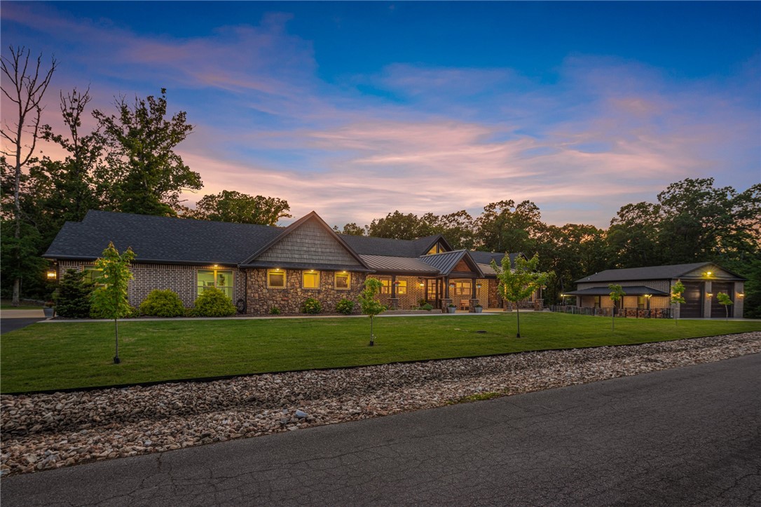 Quality Home on 5.25 Acres in Bella Vista! Private temp-controlled pool & 2,000 sf shop w/full bath & RV hookup. Attention to detail throughout w/full wired for sound, safe room, whole home generator & water filtration, electric outdoor shades cat 5 & more. Foyer entry welcomes you from covered front porch. Living space has beautiful floor to ceiling windows & cathedral ceilings with beams. Home office located off living room via sliding barn doors. Kitchen is heart of this home w/large dual islands, high end appliances including 6 burner gas range w/double gas oven, ice machine, wine fridge, prep sink & walk in pantry. Primary suite is a true owners retreat, attached bath w/soaking tub & massive walk-in shower along w/dual sinks & vanity set up. Located off primary bedroom is an owner's living space. 3 additional guest bedrooms each with their own closets & private bathrooms. Media room is sure to bring entertaining fun w/theatre style seating & large wet bar.