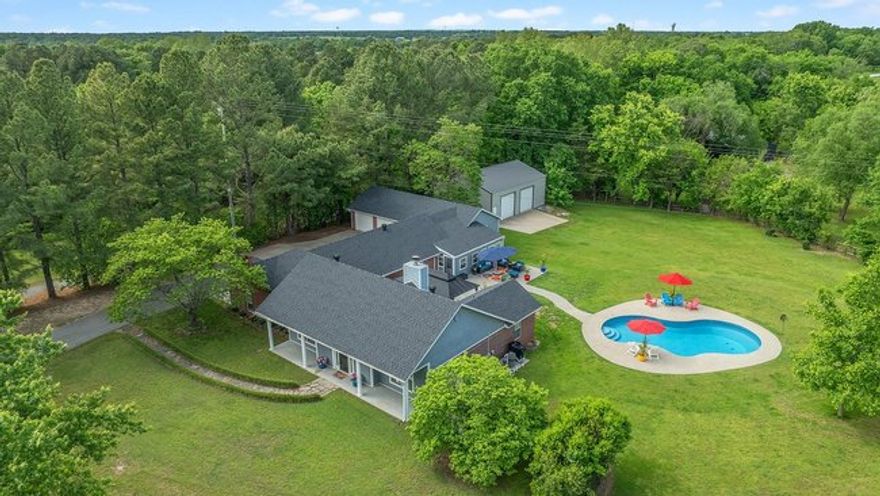 Updated 2809 Sq. ft. home on beautiful 1.5 acres. This unique home offers an in-law suite/family room with full kitchen and dining, walk-in closets and a separate HVAC system. The kitchen in main part of home has new quartz countertops in 2025. Hardwood floors, remodeled master bath with carrera tile, quartz countertops and a Jacuzzi tub. This home also features a 3 car garage, a 30x40 shop building built in 2021, new architectural roof in 2023, a sunroom, new 20x20 gazebo and an outdoor heated pool built in 2021. The glass enclosed extension to the home provides natural light and views of the outdoors. The 1200 sq. ft. shop building has a walk-in door & 2 overhead doors high enough for motor homes and other recreational vehicles.  Within minutes of schools, shopping, restaurants and Interstate 49.