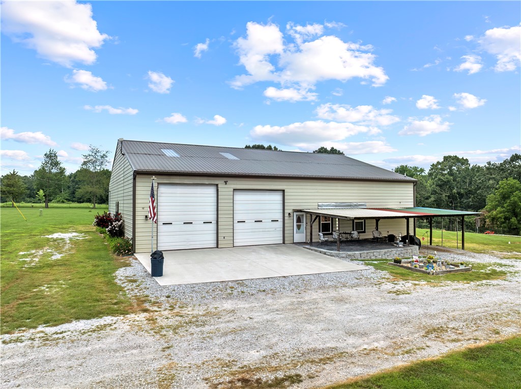 Discover the perfect blend of comfort & functionality with this unique barndominium-style residence on 2.66 level, landscaped acres in the highly sought-after Bergman School District. Surrounded by a variety of trees, flowers, & open green space, this property offers peaceful country living with modern conveniences.
The inviting covered front porch is ideal for morning coffee, while the open rear patio with a firepit sets the stage for cozy evenings under the stars. In case of a power outage, a diesel-fueled generator keeps things running smoothly.
Inside, you’ll find 1,000 sqft of living space featuring 2 bedrooms & 1 bath. The kitchen boasts beautiful hickory cabinets, plenty of storage space throughout, & each bedroom features a custom barn door for the closets, adding to the home’s rustic charm.
The highlight? A 3,300+ sqft shop that’s fully insulated & ready for any project, hobby, or storage need—perfect for car enthusiasts, small business owners, or anyone in need of serious workspace.