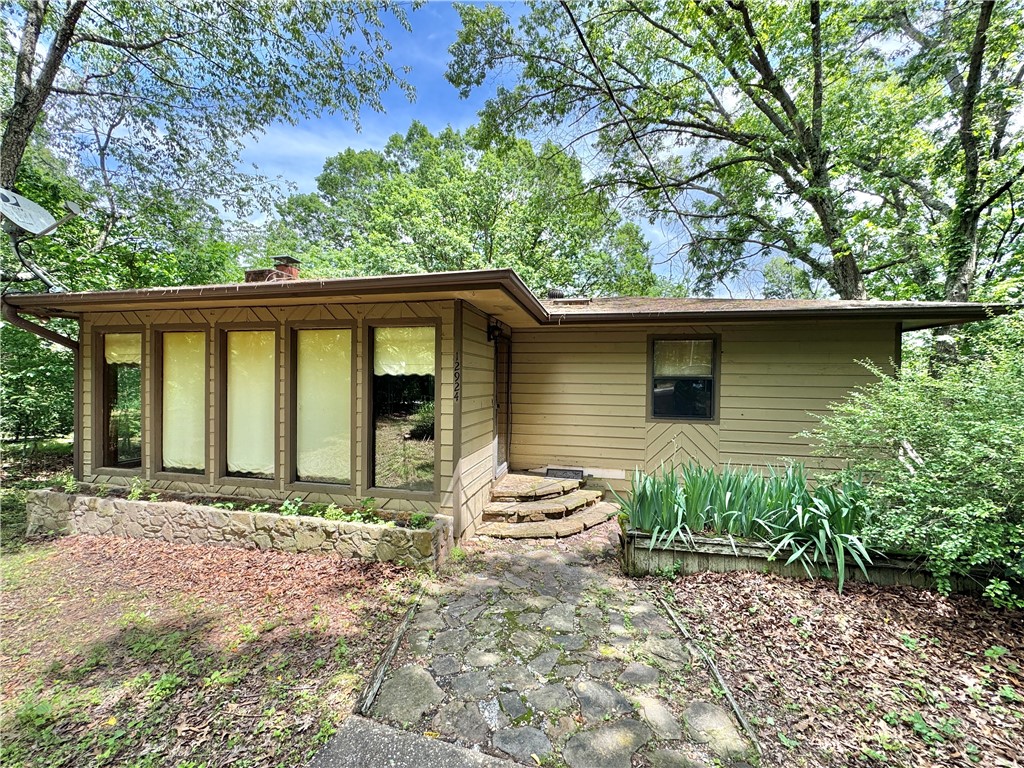 Fixer-upper with major potential near Beaver Lake! This 2 bed, 1 bath home sits on 1.8 wooded acres in Garfield, with Beaver Lake just 3 minutes away in either direction. Lost Bridge Marina is only 5 miles out, and Beaver Lake Sailing Club is 7 miles down the road. Also nearby: Pea Ridge National Military Park (15 min) and Eureka Springs (20 miles). The home features a functional layout with laundry in the basement, a large circular drive, and an expansive 1,800 sq ft deck needing TLC—perfect for outdoor living with the right touch. Sold as-is, where-is, with no seller disclosure. Whether you’re looking to renovate, invest, or build equity in a peaceful setting close to nature and water recreation, this is a rare chance to make it your own.
