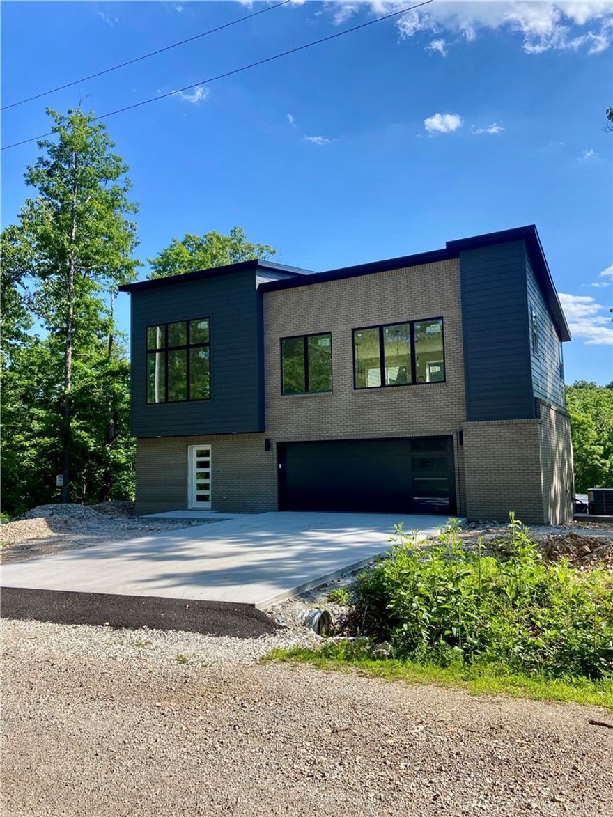 Surrounded by trees, this unique home offers a true “treehouse” feel with beautiful wooded views from expansive windows and abundant natural light. The open-concept main level features a spacious living area, oversized island, custom cabinetry, and a hidden/butler’s pantry—perfect for entertaining. The primary suite is a private retreat with serene views of the woods. The upper level includes the primary suite, kitchen, living area, and half bath, while the lower level offers two bedrooms connected by a Jack-and-Jill bathroom and a versatile flex space. Enjoy an oversized patio and a deck overlooking the woods, with no homes directly behind for added privacy. Located near the mountain biking trails and amenities that make Bella Vista so desirable, this one-of-a-kind home truly stands out.