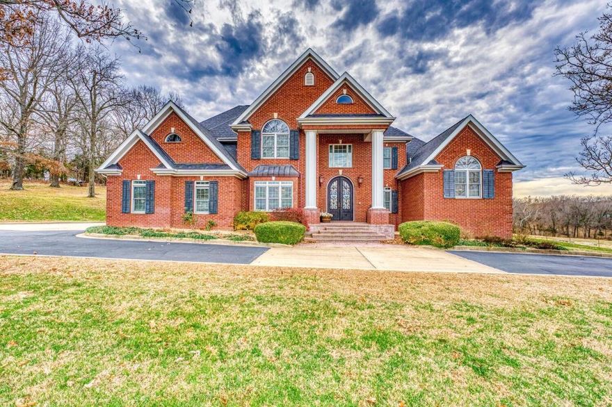 Boasting approximately 7,355 sq ft, this custom-built brick masterpiece features 7 bedrooms, 4 full baths, and 2 half baths. Every detail exudes sophistication, from the stunning curved staircase in the foyer to the vaulted ceilings, hardwood floors, and two fireplaces. The main level hosts a luxurious master suite with a sitting area, walk-in closets, a walk-in shower, jetted tub, and double sinks. The home's heart is a remarkable eat-in kitchen with modern stainless steel appliances, ample cabinets, a breakfast bar, butler's pantry, and a formal dining room. The living area is inviting with its own gas fireplace. Upstairs reveals additional bedrooms, baths, an office, and a sitting/music room.