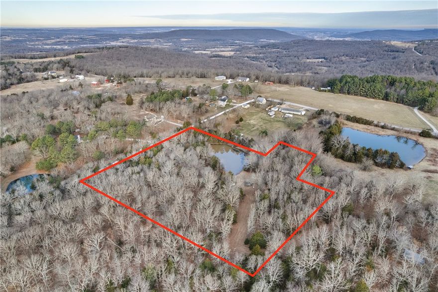 Peaceful 6.1-acre tract offering an excellent balance of privacy, usability, and convenience. Natural features include a pond, wooded coverage for seclusion, and open areas well suited for a future homesite. Recent improvements include replaced culverts along the road and driveway adding confidence for access and development. Electric and water are available on the property, helping reduce upfront planning costs, and an older septic system is present that will require replacement, with its prior installation indicating the soil successfully perked at one time. Surrounded by well-maintained neighboring properties and located just minutes from Devils Den State Park, approximately 3.5 miles from Harps in West Fork, and about 15 minutes from the Walmart Supercenter on MLK, this land delivers both lifestyle appeal and everyday convenience.