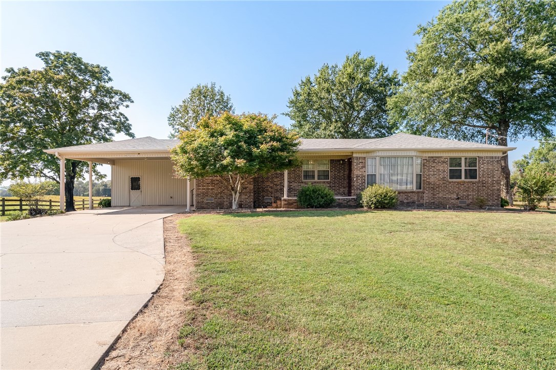 Newly remodeled, fresh and clean with outstanding features. Great for entertaining with the flow of the open floor plan. Just East on 64 Hwy between Alma and Dyer is this neat home surrounded by large oak trees. New in 2024: Shingles, some carpet, paint, sheet rocked ceiling in living areas. Newly painted cabinets, some new light fixtures, ceiling fans, & can lighting. Real fireplace with gas logs, side built-in bookshelves. Home features 3 bedrooms, 2 baths, and lots of walk-in closets. Large utility room with washer dryer that conveys. Smaller storage under carport and a shop building 12 x 16. House is surrounded by 39 acres that is not on the market. Plenty of privacy. Large deck to watch the early morning sunrise or the tree shaded late afternoons. This home has been loved by only one family.