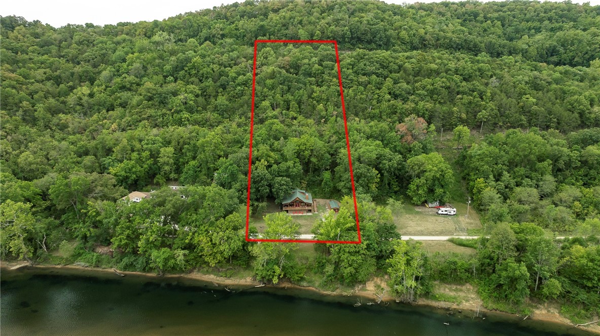 This updated lodge-style home boasts 176 ft. of White River frontage on 2.48 acres of unrestricted property complete with a path down to the river, riverside fire pit, and a "honey-hole" frequented by local fishermen and guides. With 2 bedrooms, 2 bathrooms and a loft for additional sleeping space, this cozy retreat has it all! Your family and friends will love R&R surrounded by nature and views of the river while visiting and grilling on the wrap-around deck. The wall of windows and French doors flood the open concept living area with natural light and gorgeous views. The kitchen and bathrooms are updated with luxury finishes and modern amenities. In 2023, new windows, LVP flooring, and a Culligan water filtration system were added. A fenced side yard offers safe play space for children and/or 4-legged friends. A wooden ramp alongside the entry steps provides handicap access. In addition to the gravel driveway, there is additional parking nearby. Turn-key - furniture and appliances convey. Start your vacation now!