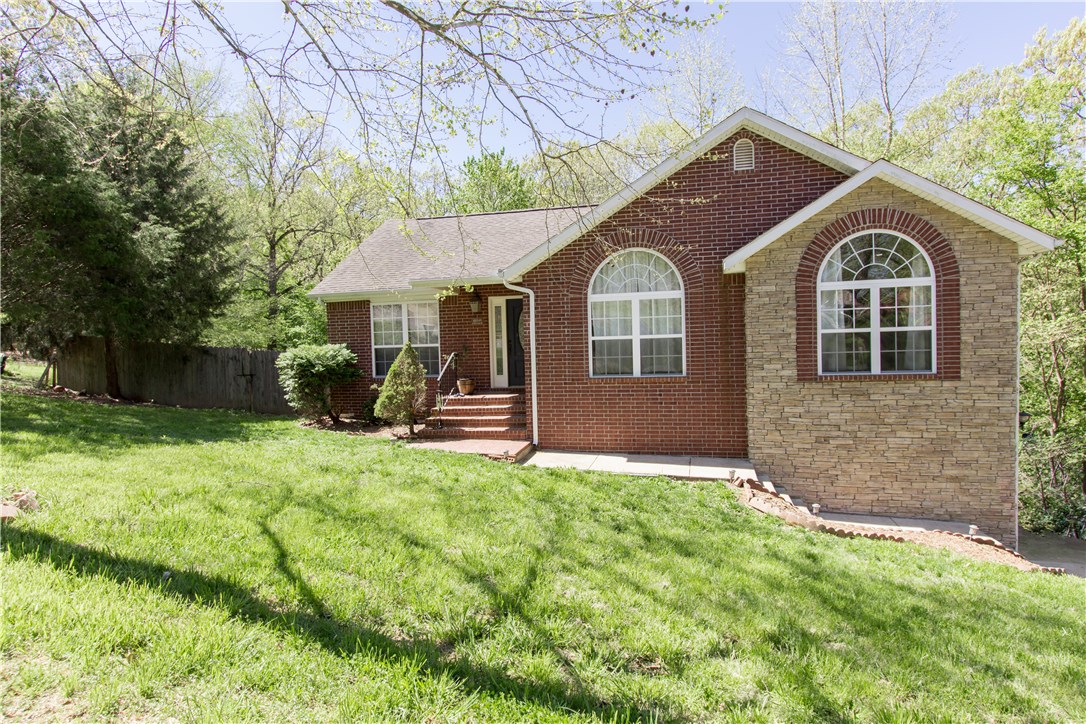 Peaceful lakefront subdivision just past the White River bridge and only fifteen minutes from downtown Springdale and the Jones Center. Great family home with three bedrooms, three full baths, and a downstairs bonus room that could be used as a fourth bedroom. Large master bedroom with walk-in closet and ensuite master bath with whirlpool tub and shower. Open floorplan on main level with living room and formal dining room with tons of natural light and French doors leading out to the upper deck. Downstairs has a large second living area, one bedroom, full bath, bonus, and utility rooms and a walk-out to the lower deck and privacy-fenced backyard. Fireplace and refinished wood floors upstairs, and recent new paint and carpet. Over-sized two-car garage. Walk to the White River in minutes. Near Sonora Elementary and Middle School, Camp War Eagle, and War Eagle Marina. House sits on 2/3 acre double lot, overlooking the Ozark's natural beauty. Amazing fall view with plentiful deer!