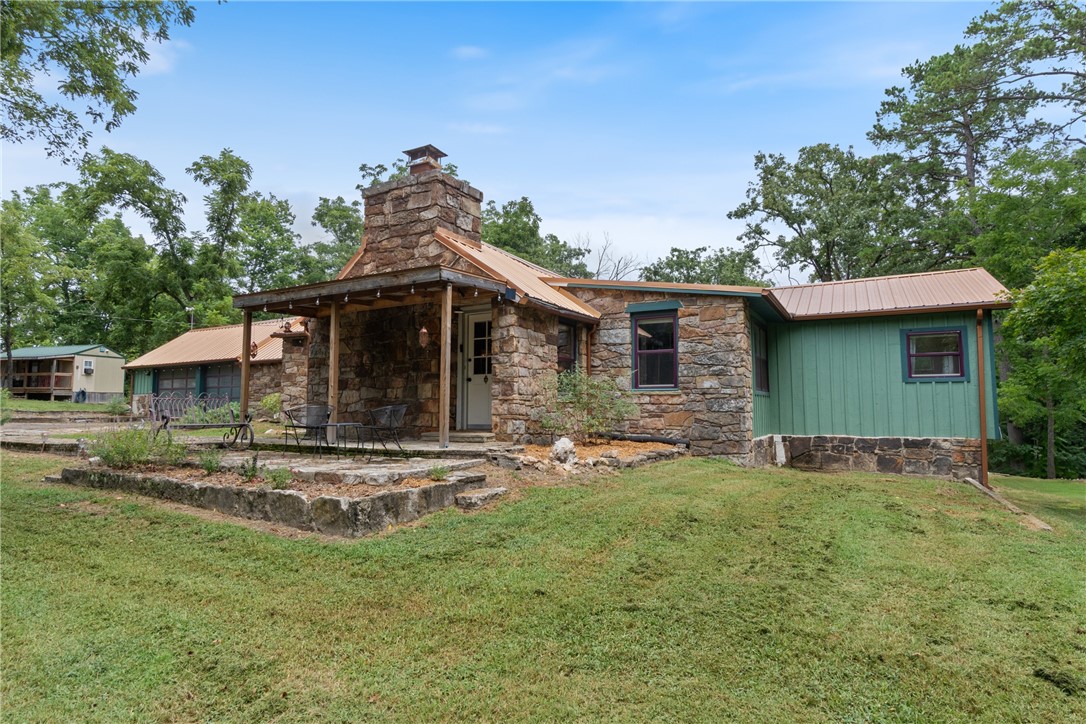 Tucked away on 4 secluded, wooded hilltop acres just minutes from historic downtown Eureka Springs, this rare two-home property offers income potential & privacy. The 1,631 sqft home has 3 bedrooms and 2 bathrooms blending vintage charm with modern updates. Featuring a stunning stone wood burning fireplace, updated kitchen with copper vent hood, live edge acacia wood countertops & beveled edge shelves, wood look laminate flooring & new lighting. Enjoy the sunroom, multiple covered patios, large closets, walk-in storage & finished attic with storage. Currently split into a functional Airbnb and a private ownerās suite with a kitchenette. Additionally the 288 sqft guest house includes 1 bed and 1 bath perfect as a rental, guest space, or studio with a kitchenette. Wildlife abounds in this peaceful retreat, with deer & hummingbirds as regular visitors. Property includes access from Washington St below for future development opportunities. Whether for rentals, personal use, or bothāthis hilltop gem checks every box.