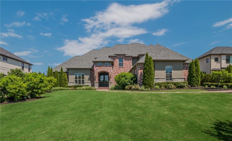 BACK ON MARKET!! Don't miss this home zoned for both Bentonville and Rogers School Districts that is completely move in ready!! High style abounds at this 5 bedroom, 5.5 bathroom estate in gated Pinnacle subdivision. Beautifully designed, featuring ebony hardwood flooring, designer Contemporary lighting, French doors, gorgeous custom cabinetry, granite countertops throughout and stunning architectural details.  All bedrooms feature an en-suite bathroom and this home has hard to find 2 bedrooms on the main level. Chef’s kitchen with oversized island, abundant cabinetry, wolf appliances & spectacular granite. Spacious media room featuring wet bar and 110" projector system with Black Diamond Light Rejecting technology. The half acre grounds are graced with lush landscaping and a covered patio for entertaining and relaxing with room for a pool!