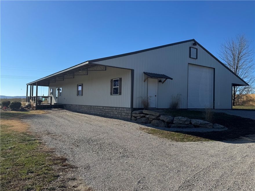 Stunning Barndominium on 5+ Acres in The Meadows. Experience Ozark living in this beautifully designed, low-maintenance barndominium on 5+ peaceful acres in the desirable Meadows Subdivision, just minutes from downtown Berryville. The home features metal siding and roof, radiant-heated stained concrete floors, and an open-concept layout. An outside wood furnace efficiently supplies heat to the water heater and radiant flooring. The gourmet kitchen offers cherry cabinetry, stainless steel appliances, and ample counter space. The main-level primary suite includes an ensuite bath and walk-in closet, along with a convenient half bath and oversized laundry/mudroom. Upstairs are two large bedrooms and a dedicated children’s library/playroom. The fully fenced property is ready for livestock and includes a 40x40 insulated shop/garage with foam insulation, automatic overhead door, and workbenches. Rural water, septic, home warranty, and a brand-new HVAC system scheduled for January 2026 complete this exceptional property.