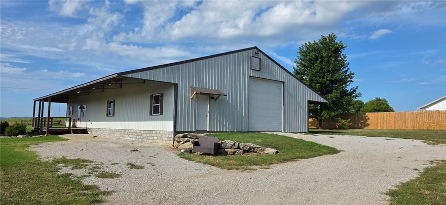 Enjoy country living in this beautiful two-story home located in the desirable Meadows Subdivision, minutes from downtown Berryville. Nestled on 5+ acres, this low-maintenance property features metal roof w metal siding. Step inside to an inviting open-concept featuring radiant-heated stained concrete floors, spacious living & dining area. The gourmet kitchen has rich cherry cabinetry, stainless steel appliances w/ample counter space—ideal for entertaining. The primary suite offers privacy w/an ensuite bath & lrg walk-in closet. 1/2 bath is located just off the dining area. An oversized lndry/mudroom connects directly to garage/shop. Upstairs, you'll find 2 generously sized bedrooms & full bathroom. The 40x40 insul. shop/garage has foam insulation, built-in workbenches, automatic garage door. Utilities incl. rural water & septic system. Whether you're looking for a peaceful retreat or home w room to grow, this property captures the essence of Ozark living at its finest. Home comes w a one year Home Owners Warranty