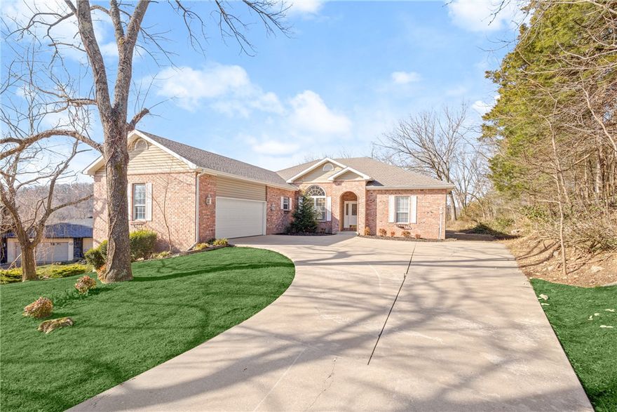Golf Views and Bike Trails right out your door! This home has been meticulously maintained and has all new paint and brand-new roof. Foyer entry leads into the spacious living room, hardwood floors throughout living spaces. Formal dining space. Living room has golf course views and features a gas fireplace. Large kitchen has gorgeous wood cabinets, great natural light, large eat in space, and granite counters. Two guest bedrooms and guest bath on split layout. Laundry room with extra storage. The primary suite is large and has access to the back deck, hardwood floors, and large windows with beautiful private views. The attached bath and walk in closet create a great relaxing retreat. Walkout workshop is perfect for extra storage, bike shop, or hobby room! Enjoy the natural beauty of the woods and bluffs from your large covered deck. Unbeatable location next to all the best Bella Vista has to offer and right across the highway from OZ Bike Trail Park. Amenities include pools, gyms, club houses, lakes, golf and more!