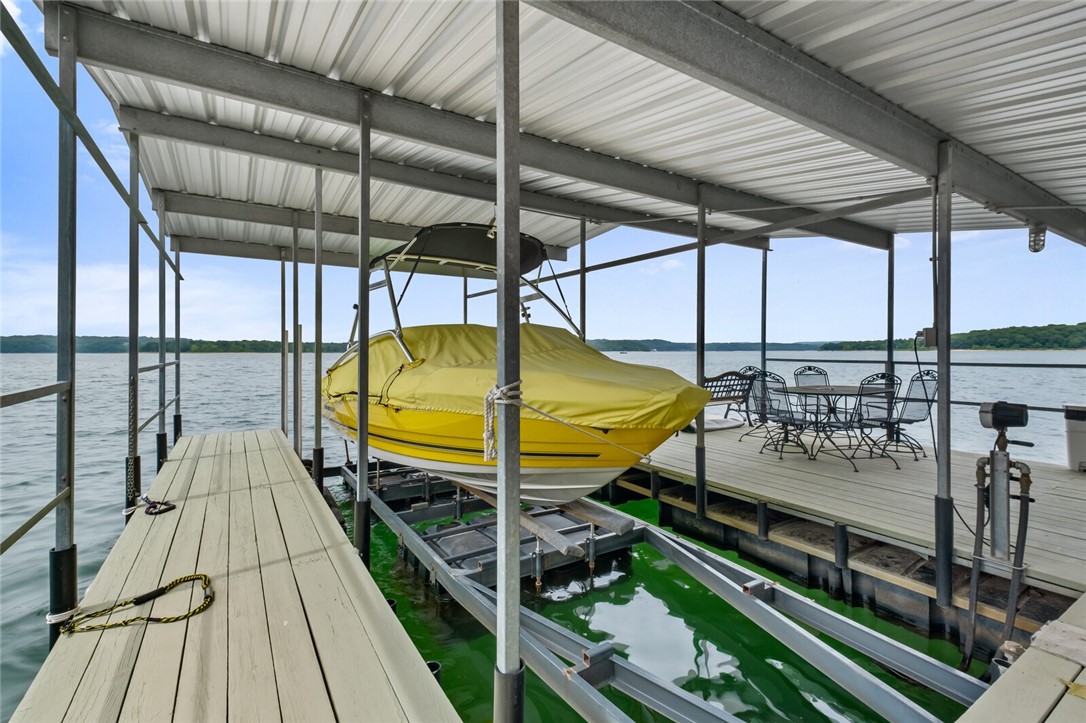 Exceptional lakefront living just at the waterās edge. Stunning views & easy stroll to private boat dock equipped w/10x26 slip & lift, 2 jet ski pads, electric & covered swim platform make this an entertainerās delight. Thoughtfully designed w/dramatic entry, formal & informal living, 2 FP's, Chefās kitchen, Brk area & Sunroom w/floor to ceiling windows. Eat-in Kitchen boasts 8ft island, double ovens, 5 burner gas cook top, Subzero Fridge plus wine fridge, pantry & glass front cabinetry. Primary Suite & luxurious bath w/soaking tub, walk-in shower, dual closets & inviting French doors to waterside deck or garden patio. Guest suite completes main level. Downstairs offers guest suite w/walk-in closet, kitchenette, 2nd laundry & access to screened porch. Flex/bonus/bunk room for overflow guests plus media/craft/game room. Enjoy views from office w/lake access. Paved path to private deck area & boat dock. Many updates & amenities, storm shelter area, abundant storage & oversized garage. Your own private oasis.