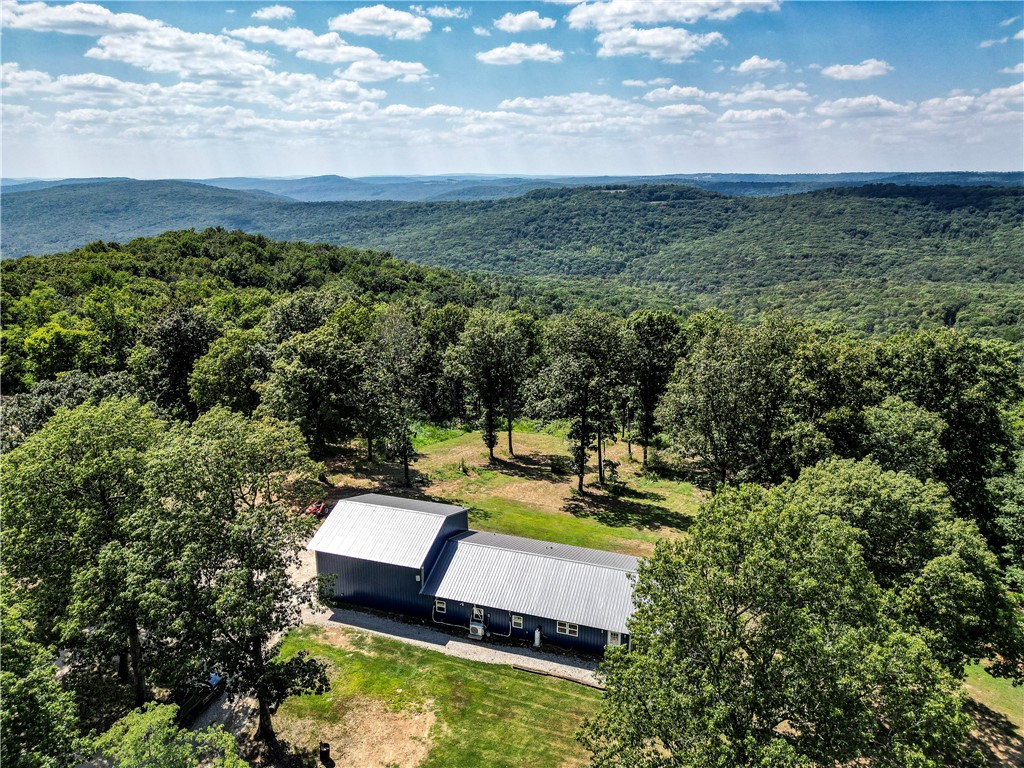 Looking to get away from the hustle of Northwest Arkansas, but still have access to all it offers? This picturesque custom metal home sits atop a Winslow mountain with breathtaking views, few neighbors and still has the modern conveniences you want. Open concept living with natural light flowing through the many sliding doors takes advantage of the wooded surroundings so you don't miss the natural wonder around you. You'll have four bedrooms, two full baths and an attached garage with space for an RV or utilize it to house your shop equipment. The property boasts 13.50 acres in total, but the current owners have cleared approximately 3+ acres for you to enjoy as you see fit. It's also one of the few properties in the area with public water and if you're in need of high speed internet, then this one has you covered with fiber optic internet already in use at the house.